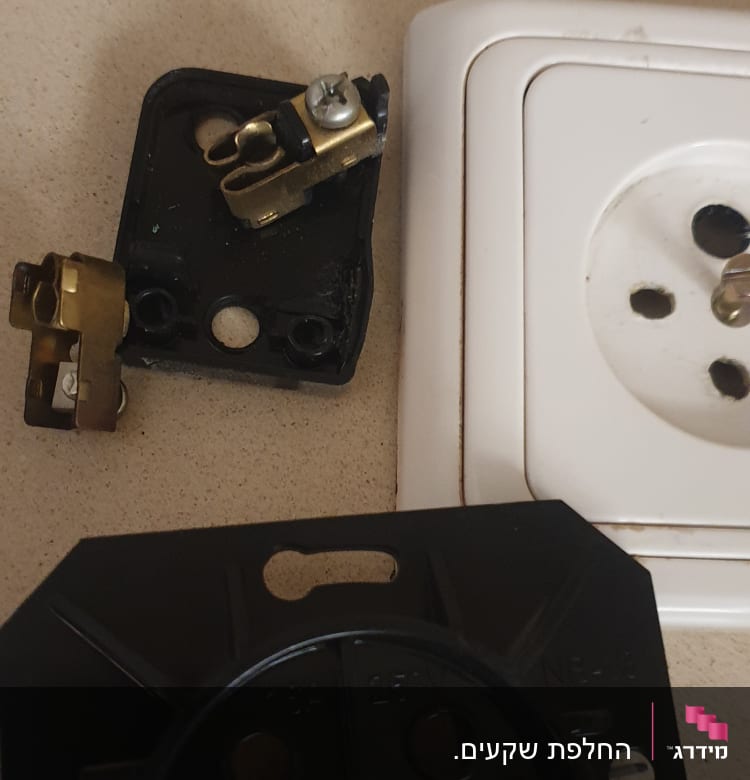 חלקי שקע חשמלי מפורקים על שולחן